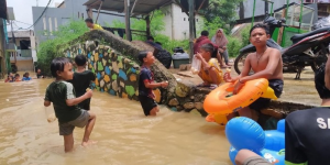 Merasa Seperti Kolam, Anak-Anak Berenang Saat Banjir di Cawang